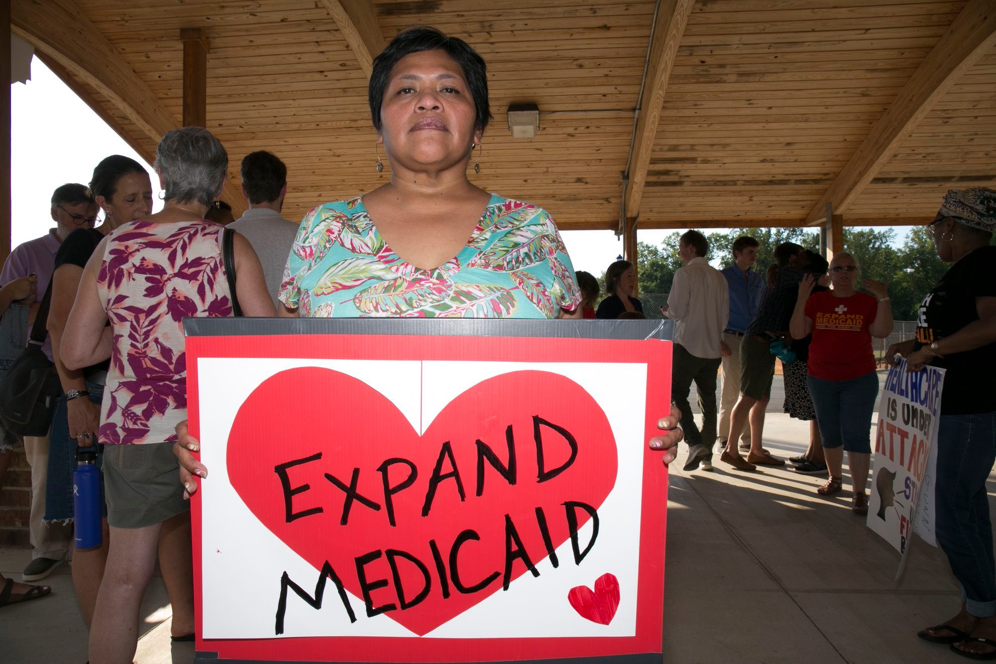 a woman holding an Expand Medicaid sign