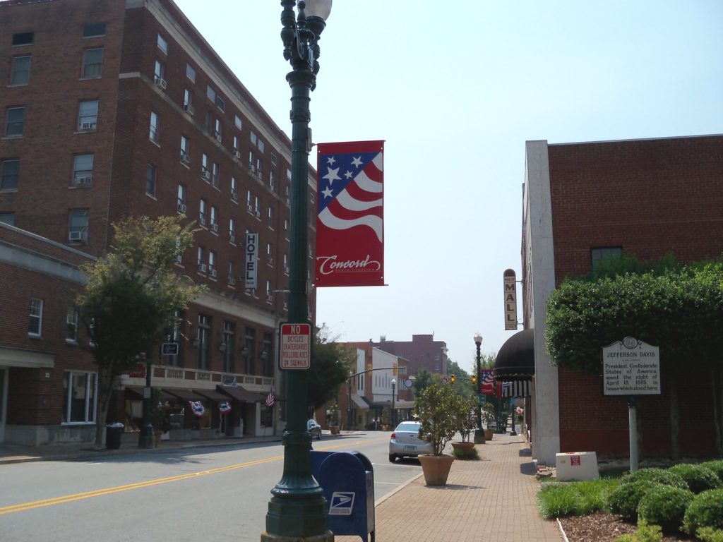 Photo of downtown Concord North Carolina with brick buildings and a commercial main street. 