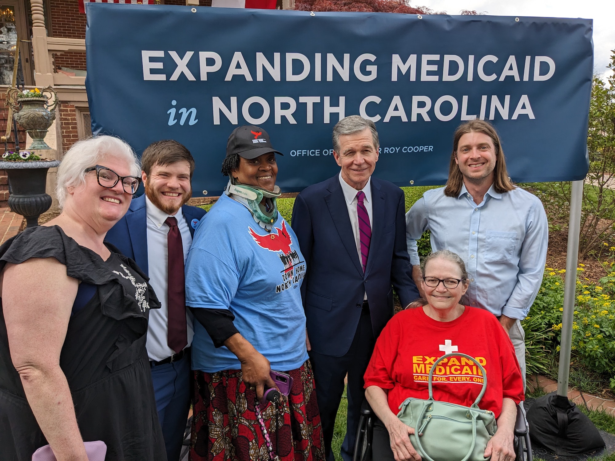 Members of Down Home NC celebrating with Governor Roy Cooper after the successful passage of Medicaid expansion in North Carolina