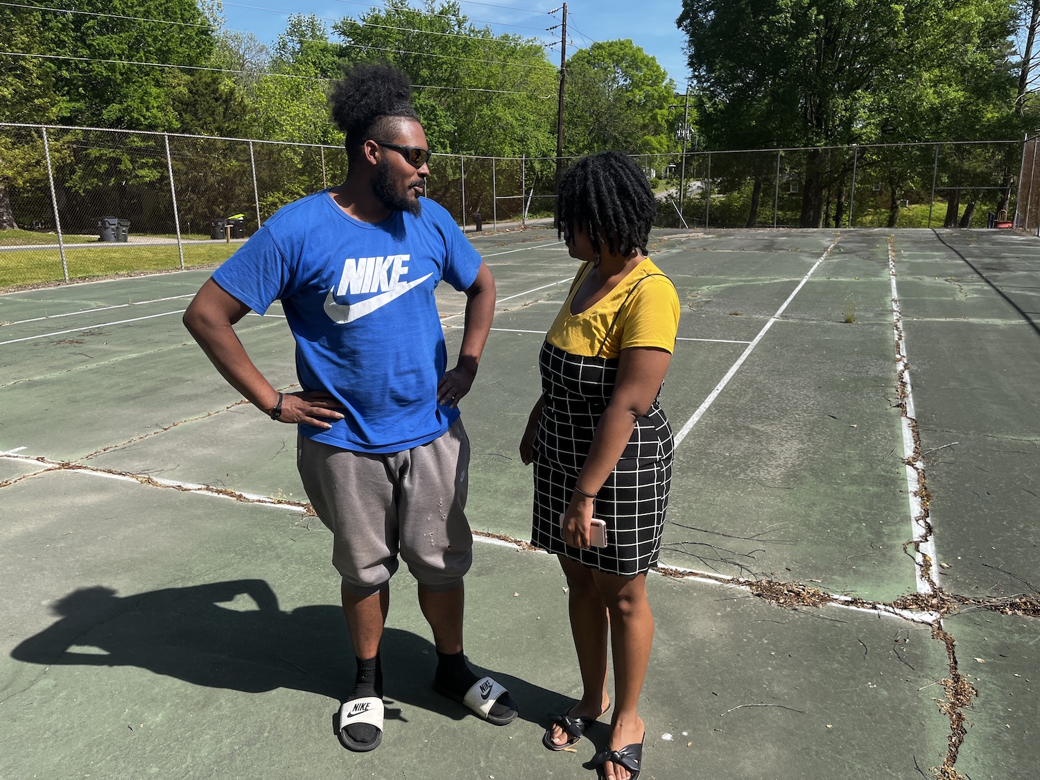 Members William Johnson and Myla Pettiford stand in the location of the old basketball courts in Granville Street Park in Oxford, N.C.. The city took out the nets and put in a tennis court, then took out the nets for the tennis court. The space has been abandoned and become a cracked concrete slab. But our members have talked with community members and there's a new vision for what used to be a thriving public space. It can become a hub for kids and families again!