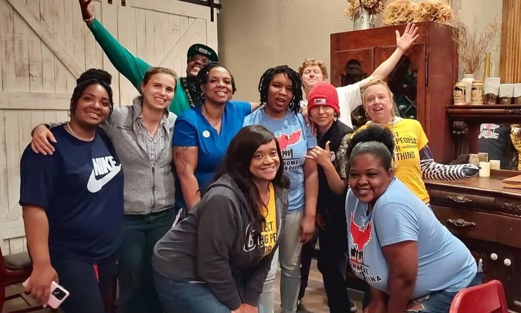 A jubilant group of dedicated volunteers from Granville County, beaming with pride and joy, celebrating their successful door-to-door canvassing efforts.